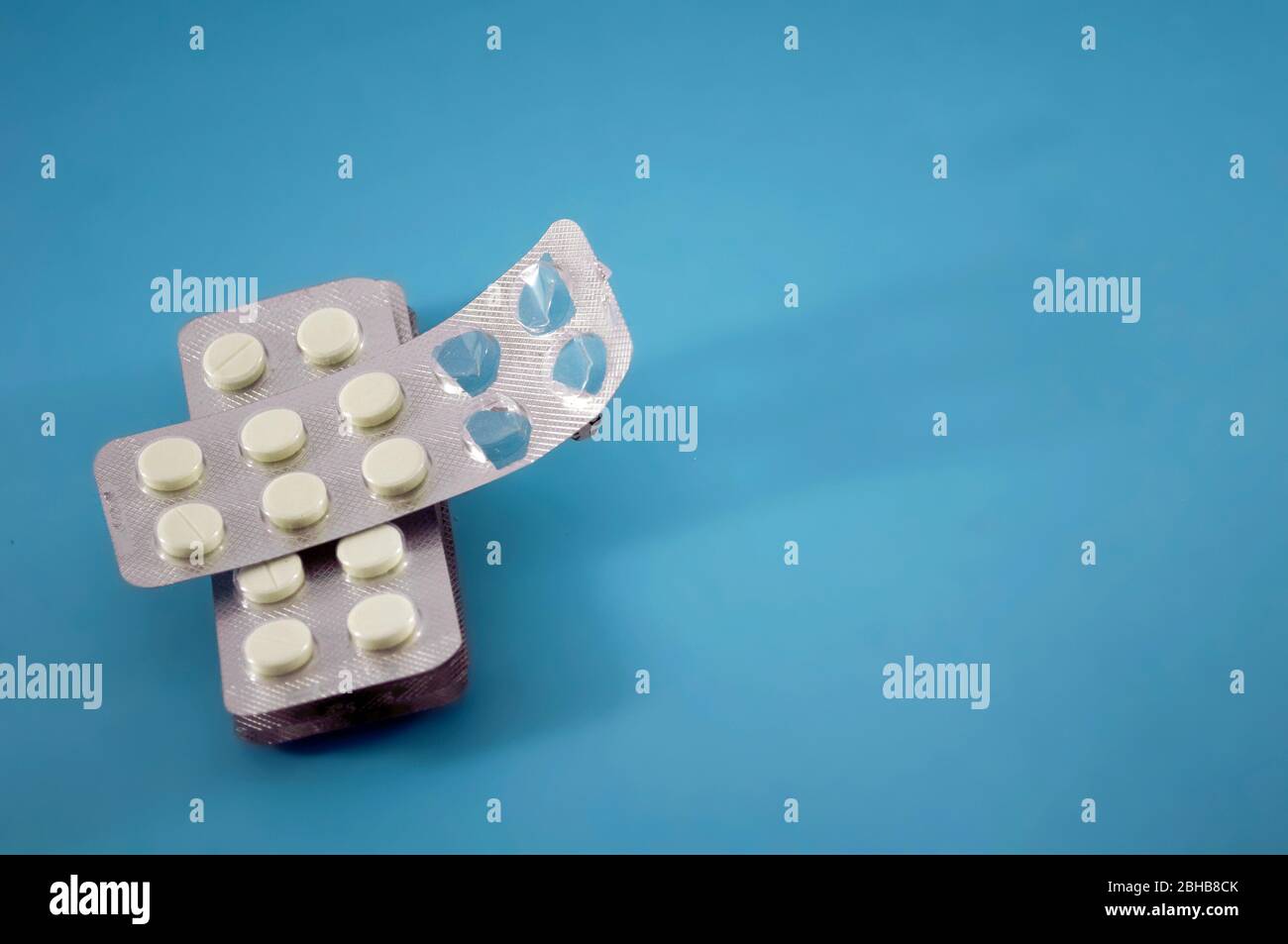 Halb leere Blister mit weißen Pillen, Vitaminen, Tablette, Medizin auf blauem Hintergrund mit Platz für Text Stockfoto