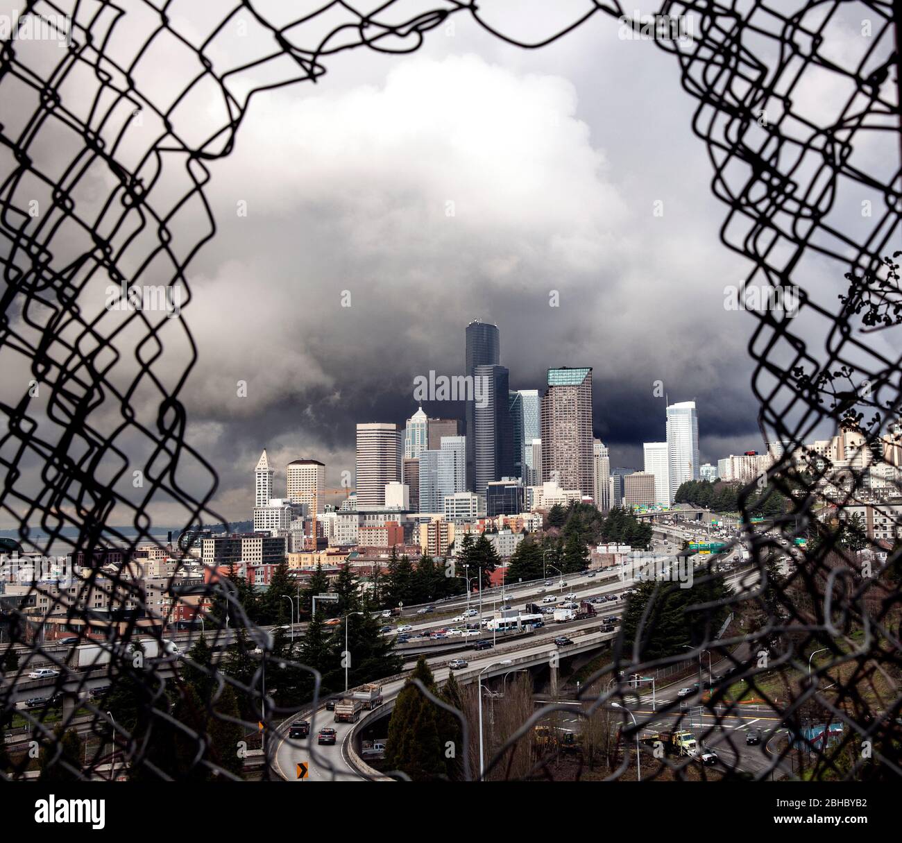 WA17436-00...WASHINGTON - Seattle Skyline durch ein Loch in einem Zaun von Dr. Jose Rizal Park entlang 12 Ave South auf Becon Hill gesehen. Stockfoto