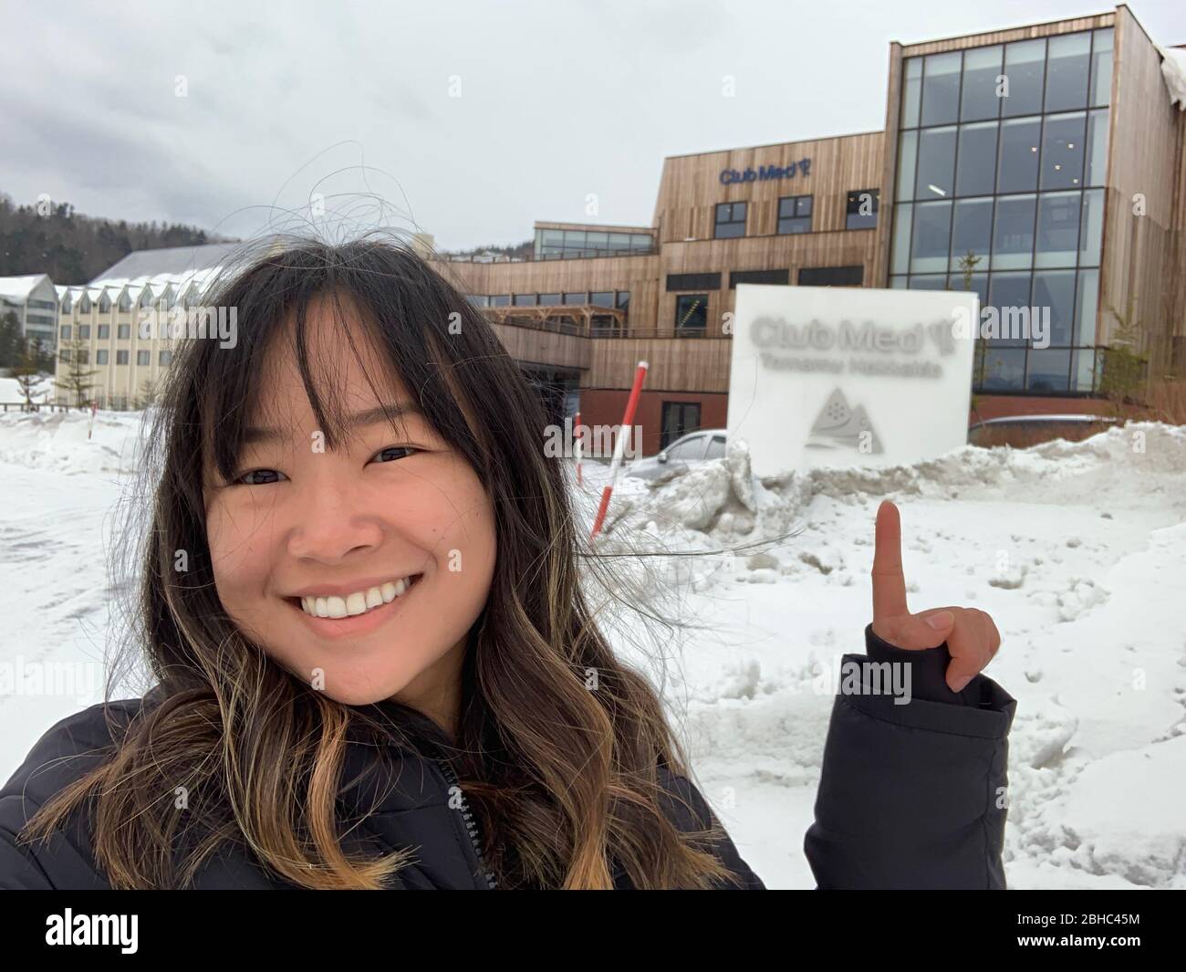 6. März 2019: Club Med Tomamu Japan - Junge asiatische Frau lächelt vor dem Club Med Gebäude Stockfoto