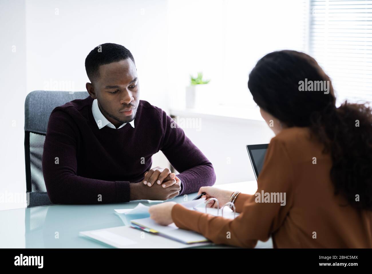 Junge Finanzberater diskutieren Rechnung mit Ihrem Kunden am Arbeitsplatz Stockfoto