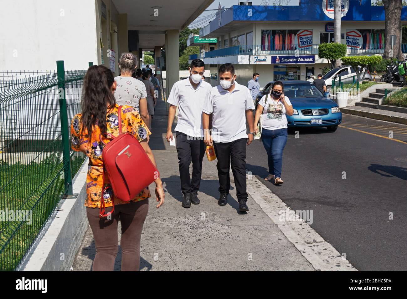 1. April 2020 - mehrere Personen warten draußen, um einen Supermarkt in der Hauptstadt von El Salvador während der etablierten Quarantäne zu betreten. Stockfoto 1. April 2020 - mehrere Personen warten draußen, um einen Supermarkt in der Hauptstadt von El Salvador während der etablierten Quarantäne zu betreten. Stockfoto