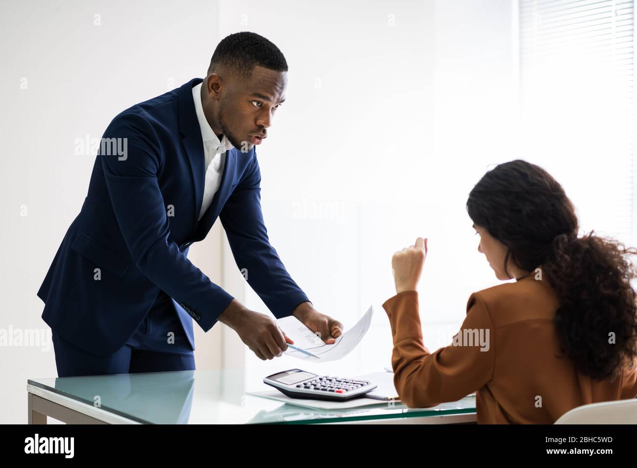 Close-up Geschäftsmann Übersicht Dokument zu weiblichen Angestellten am Arbeitsplatz Stockfoto