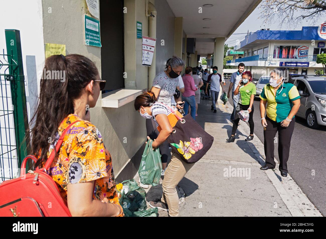 1. April 2020 - Frau, die Lebensmitteltaschen nach dem Einkaufen in einem San Salvador Supermarkt bestellt. Stockfoto 1. April 2020 - Frau, die Lebensmitteltaschen nach dem Einkaufen in einem San Salvador Supermarkt bestellt. Stockfoto