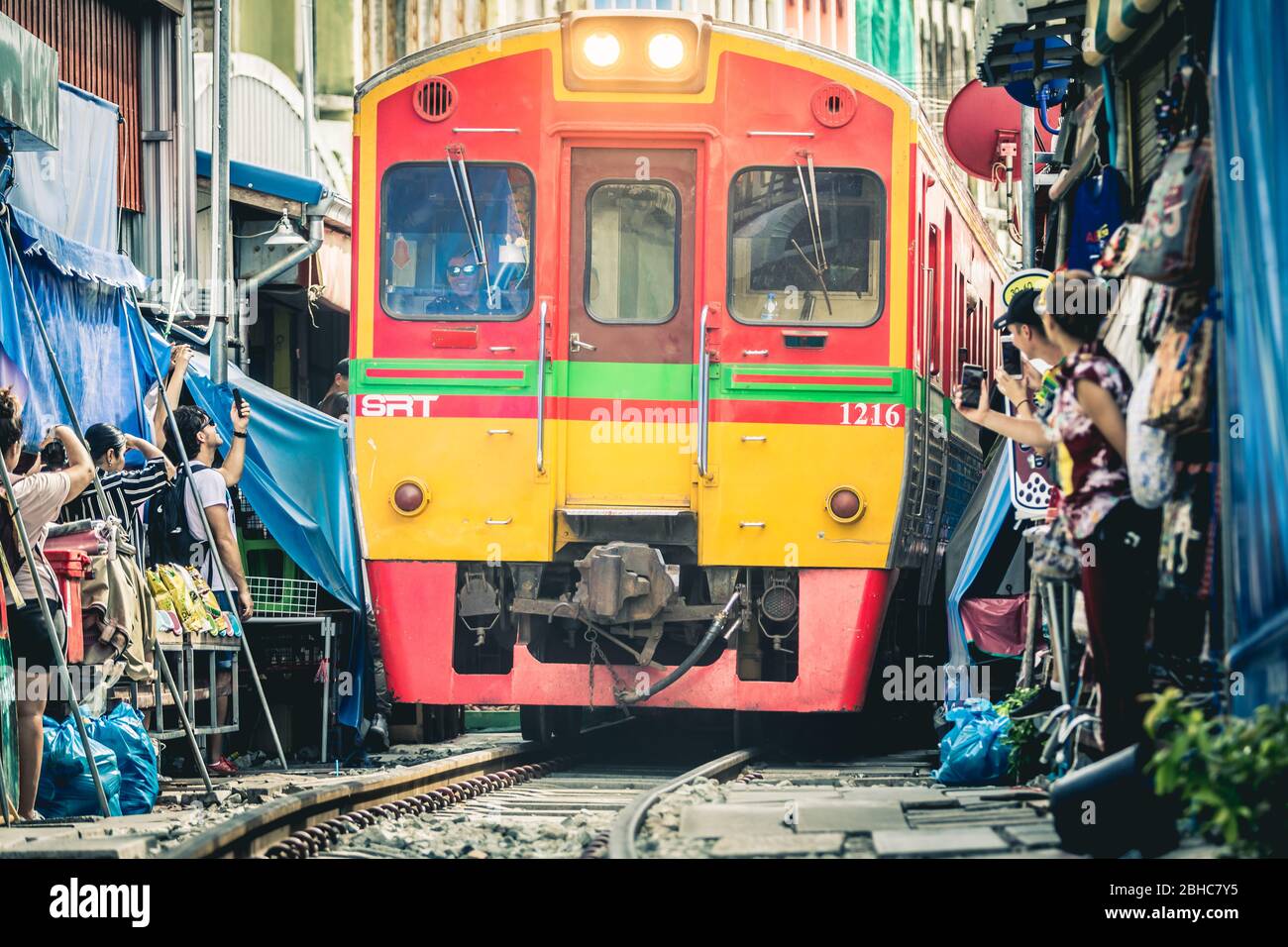 Samut Songkhram. Thailand. 23. Juli 2019: Die Eisenbahn wurde berühmt für ihre Strecke durch den Maeklong Eisenbahnmarkt. Wenn sich ein Zug nähert, aw Stockfoto