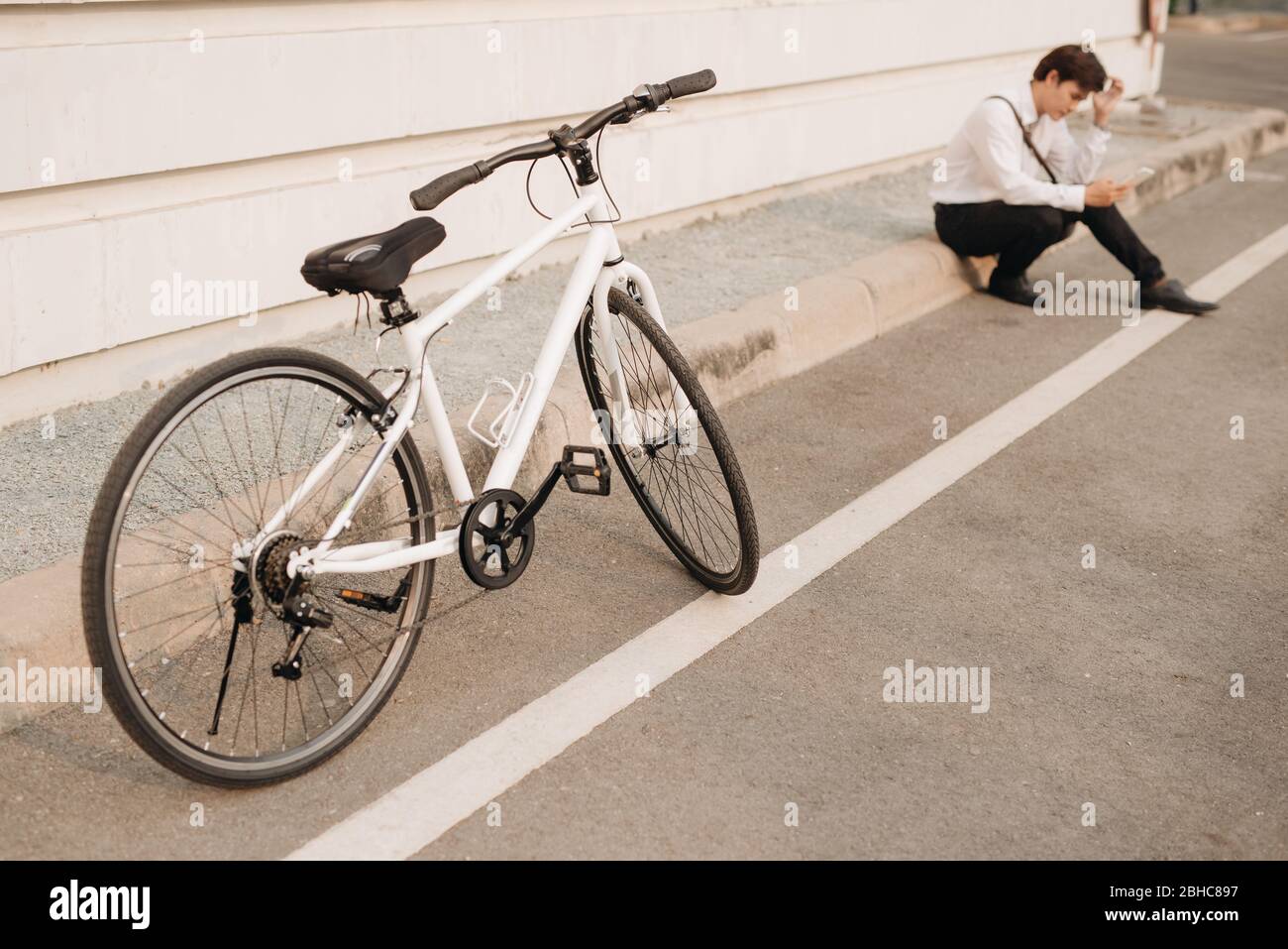 Asiatischer Mann unglücklich, wenn er mit seinem Handy in der Straße. Stockfoto