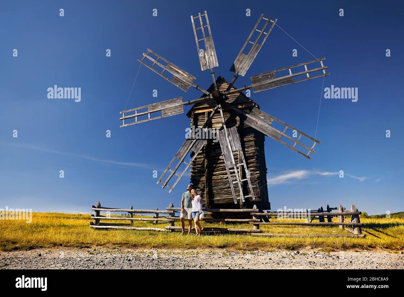 Paar Tourist in der Nähe von alten traditionellen Wind Mill in Nationale Architektur Museum in Pirogowo, Kiew, Ukraine posing Stockfoto