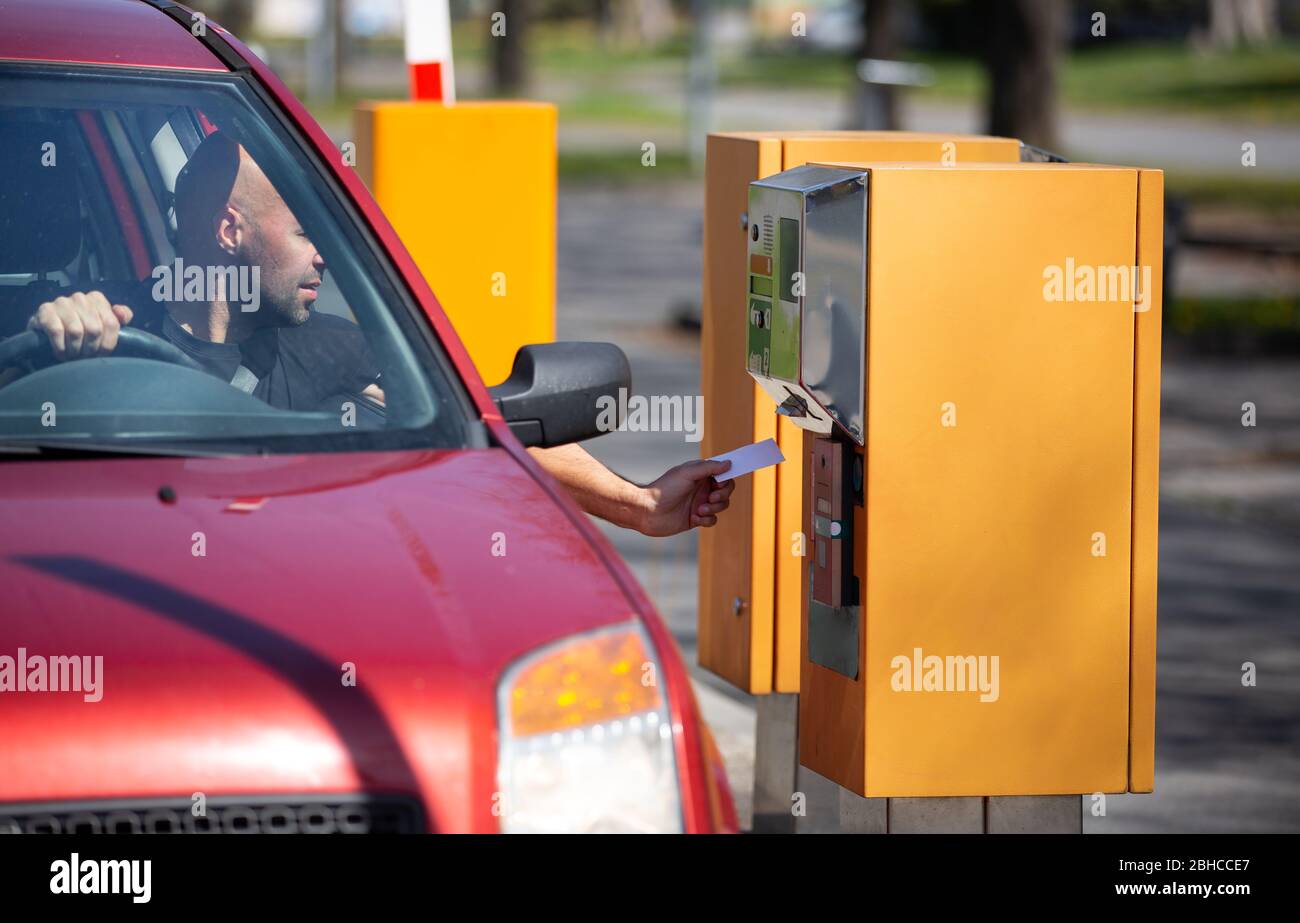 Mann Fahrer nehmen, validieren Sie ein Ticket aus dem Automaten für das Parken in privaten Bereich Stockfoto