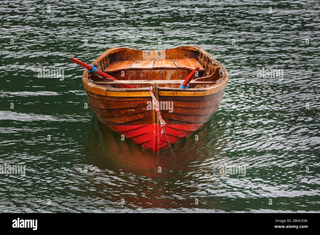 Rotes Ruderboot, das am Idrosee oder Lago d'Idro, Lombardei, Italien, festgemacht ist. Stockfoto