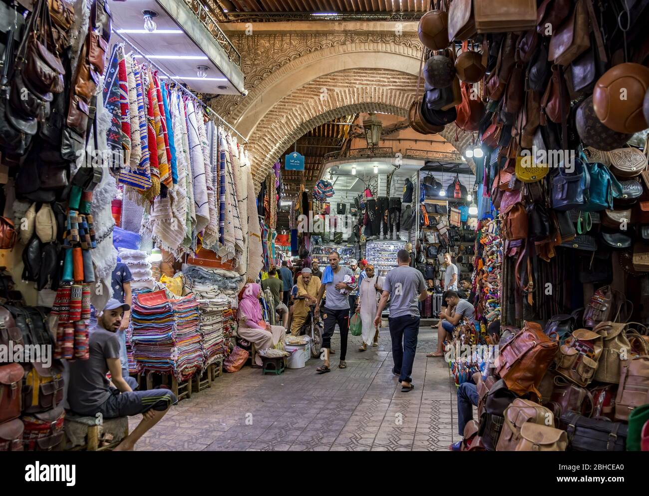 Typische Straßenansicht des Medina Bazaar von Marrakesch in Marokko. Voll mit hängenden Waren. Lieferanten und Käufer. Stockfoto