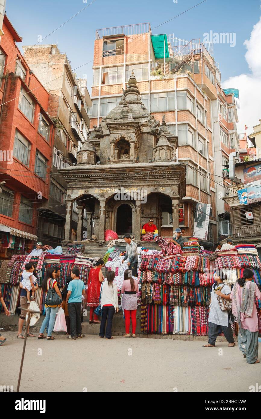 KATHMANDU, NEPAL - 29. SEPTEMBER 2012: Auf den Stufen eines antiken Tempels werden Pashmina-, Kaschmir- und Yakwolle-Textilien verkauft Stockfoto