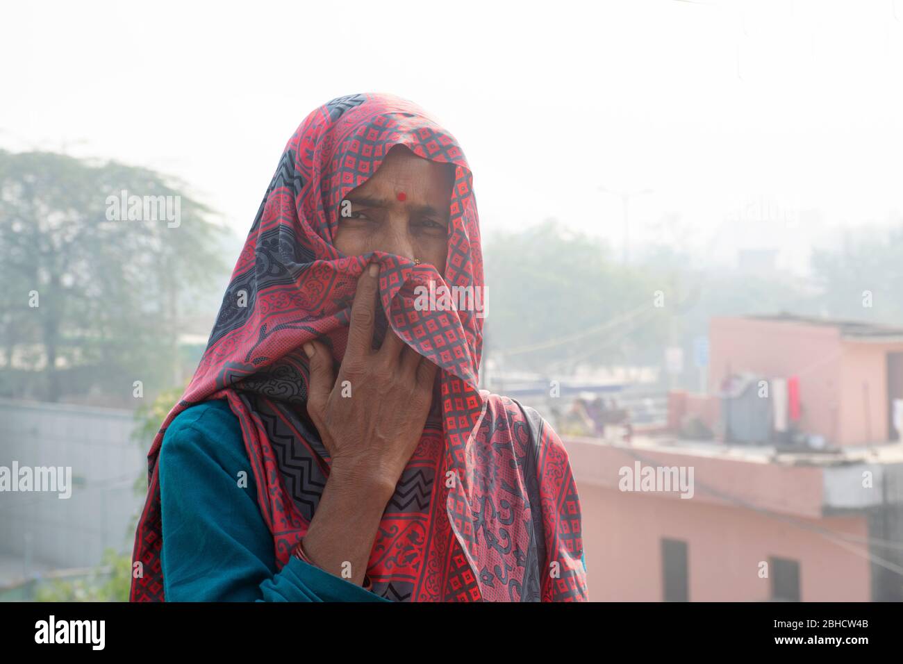 Frau bedeckt ihr Gesicht mit Saree als Maske Stockfoto