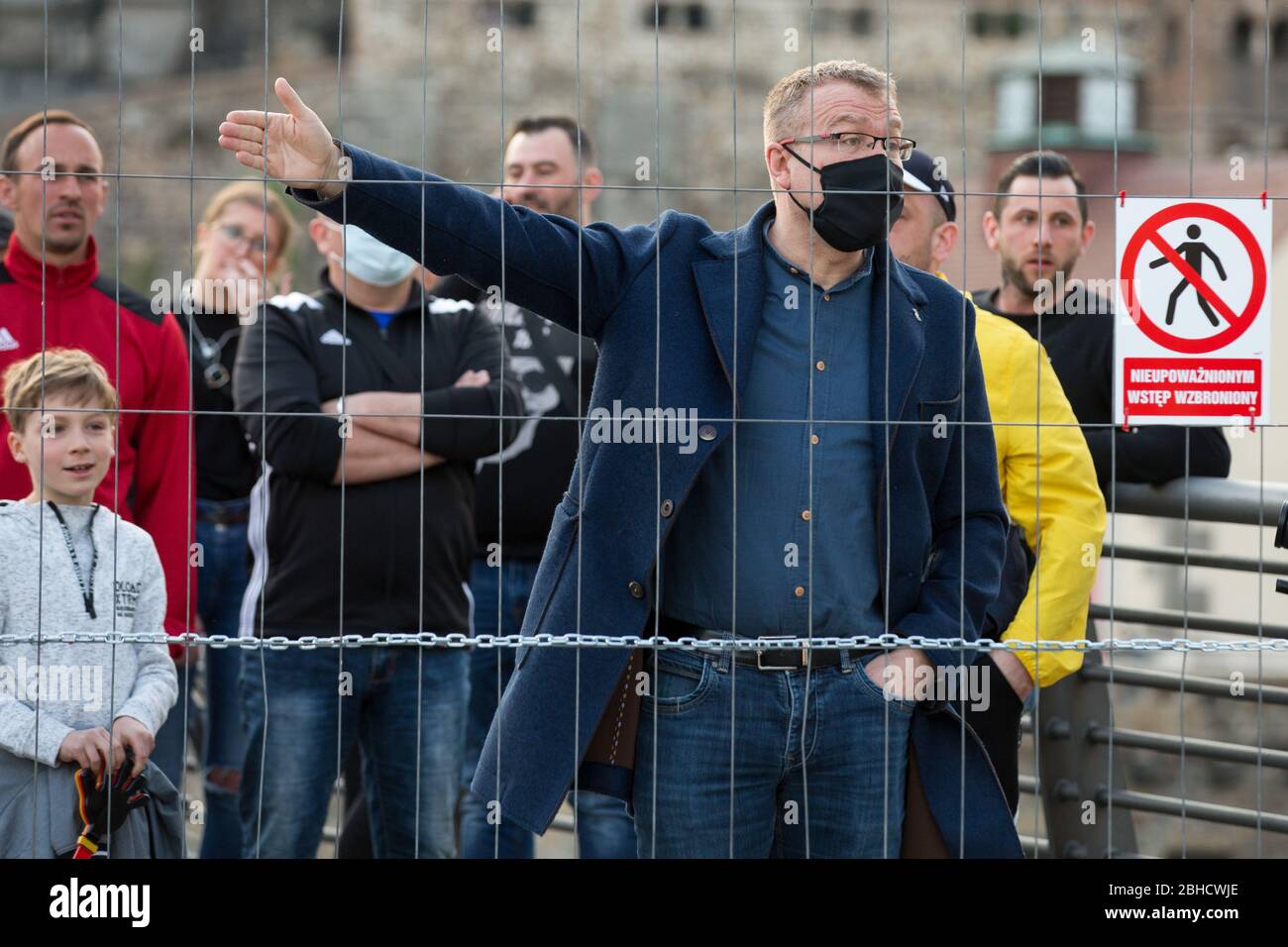 Zgorzelec, Polen. April 2020. Ein Protestler mit Gesichtsmaske tagt während der Demonstration hinter dem Zaun auf der deutschen Seite der Zgorzelec-Gorlitz-Brücke.Hunderte polnisch-deutsche Grenzbewohner protestieren gegen Virenschutzmaßnahmen, da sie ihnen täglich den Weg zur Arbeit versperren. Als Reaktion auf die COVID-19-Pandemie verlangen beide Länder, dass sich die Eintretenden einer 14-tägigen Quarantäneperiode unterziehen, obwohl Deutschland eine Ausnahme für Grenzgänger macht, Polen nicht. Quelle: SOPA Images Limited/Alamy Live News Stockfoto