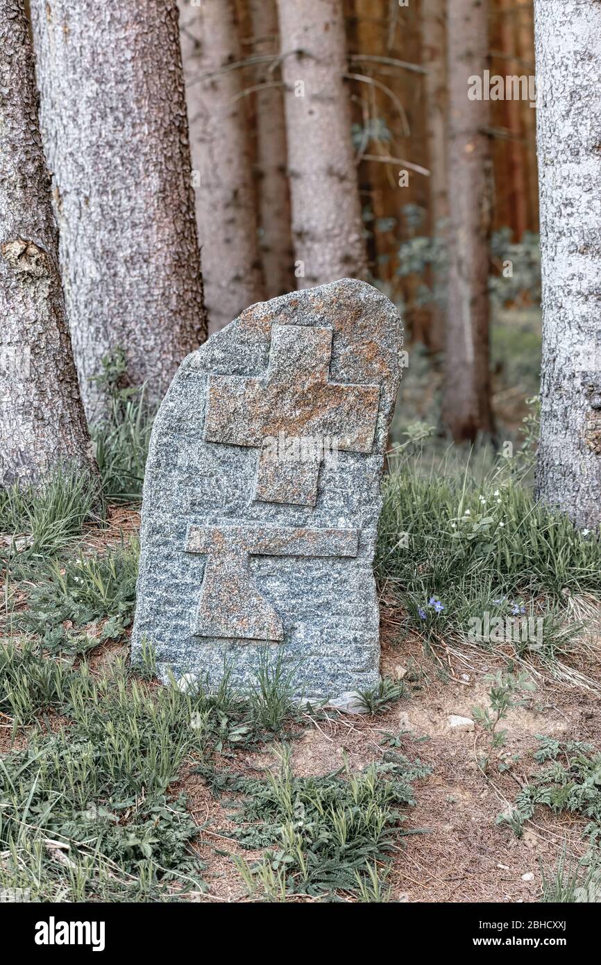 Alte Grenzmarkierung auf Felsen am Wald. Auf Stein geschnitztes Symbol des Kreuzes und Axt. Tschechische Republik Stockfoto