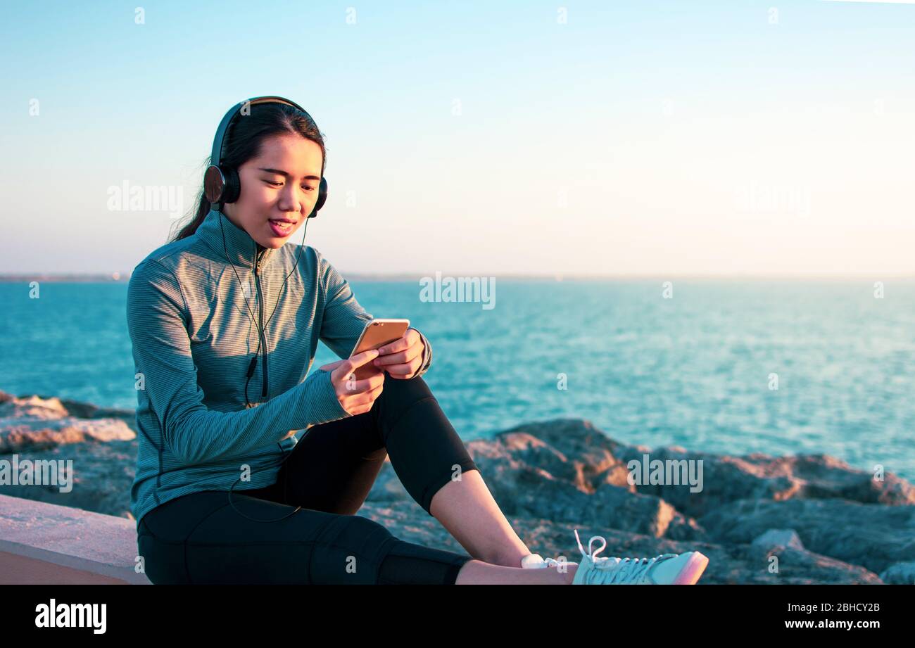 Asiatische Mädchen Musik am Meer Stockfoto
