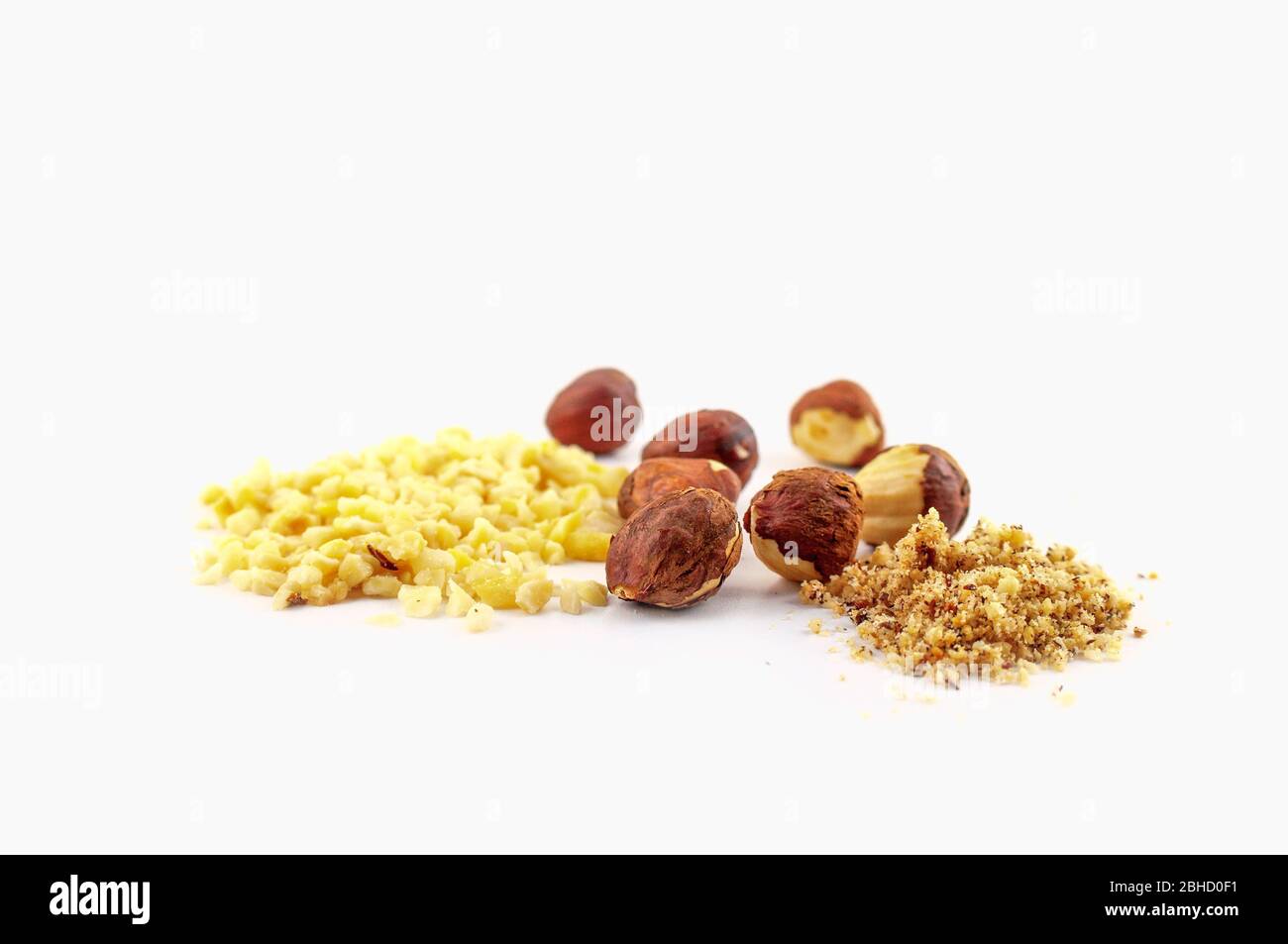 Ein Haufen gehackter Mandeln und ganze Haselnüsse auf weißem Hintergrund isoliert. Stockfoto