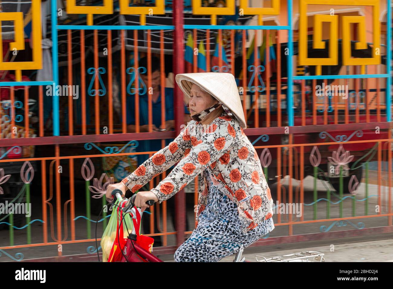 Mittlere Alter vietnamesische Frau trägt traditionelle konische Hut , non la , Fahrrad fahren , Sa Dec, Mekong Delta , Vietnam, Asien Stockfoto