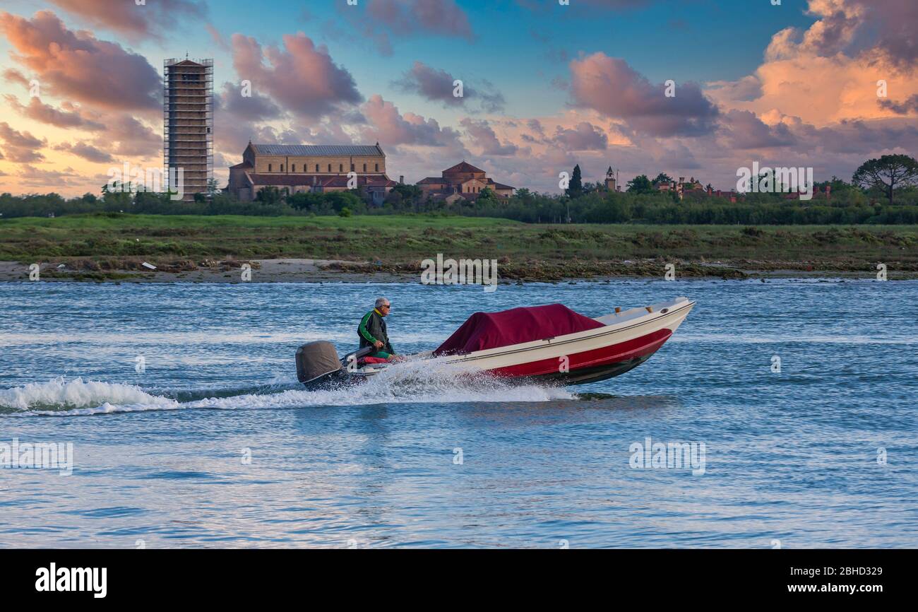 Mann, die Lenkung roten Bootes in Venedig Stockfoto