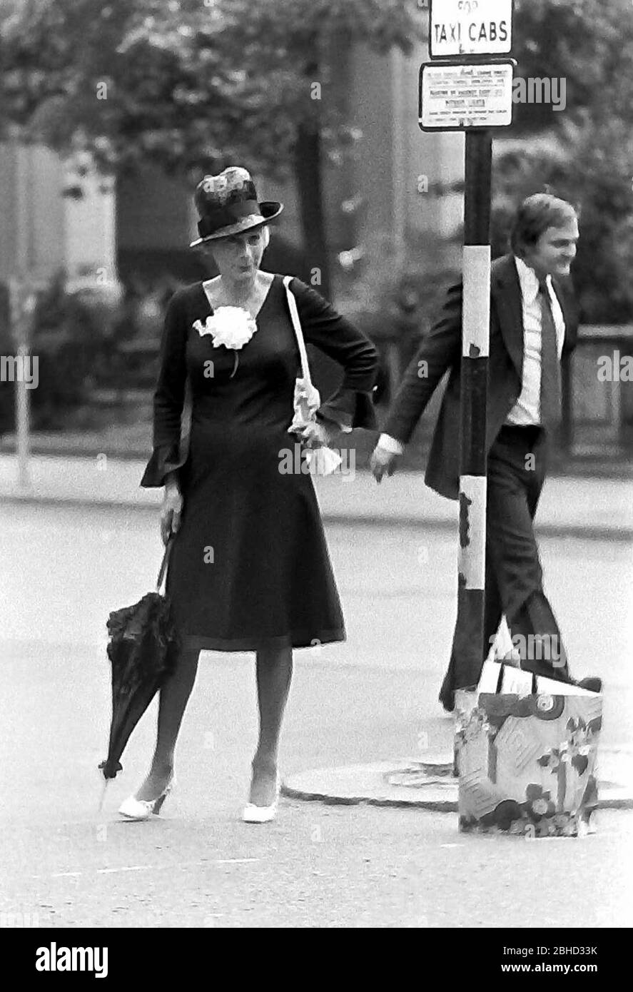 Das tägliche Leben auf den Straßen in Manchester, England, Großbritannien im Jahr 1974. Eine elegant gekleidete Frau wartet auf ein Taxi an einem Taxistand. Stockfoto