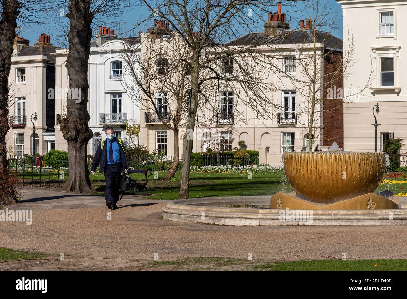 Ein Mann spaziert durch die Dane John Gardens, Canterbury Kent UK, und trägt während der Sperre des Coronavirus 19 eine Maske. Stockfoto