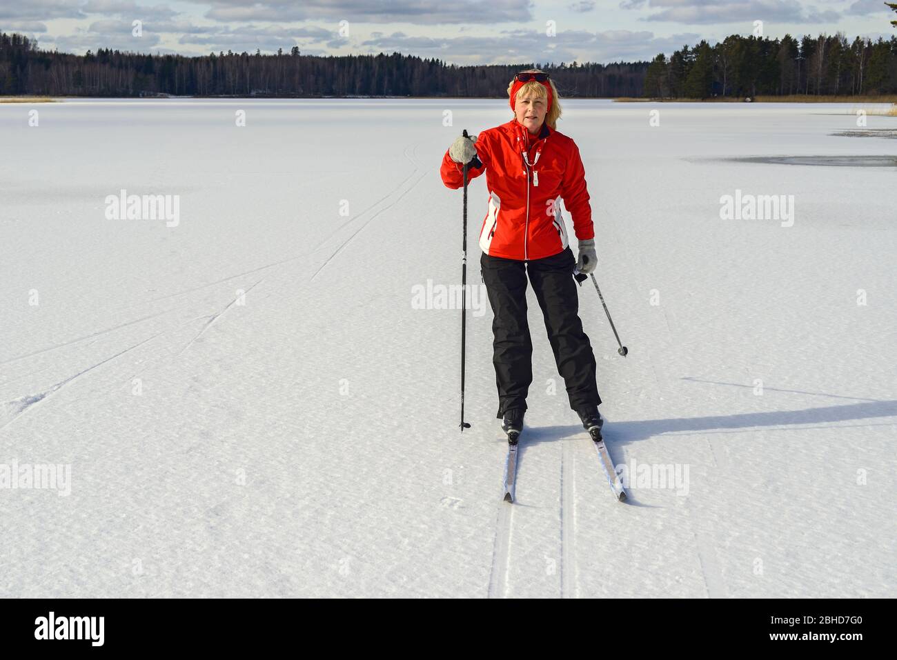 Eine ältere Frau Langlauf auf auf dem See Ålsjön, Regna, Finspång, Östergötland Stockfoto