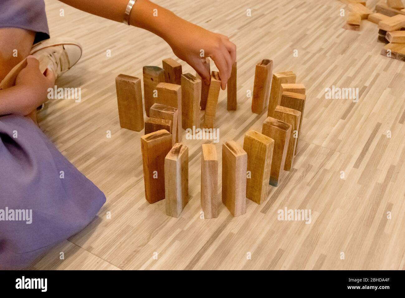 Der Holz-Domino, der von der Hand eines Mannes aufgereiht wird Stockfoto