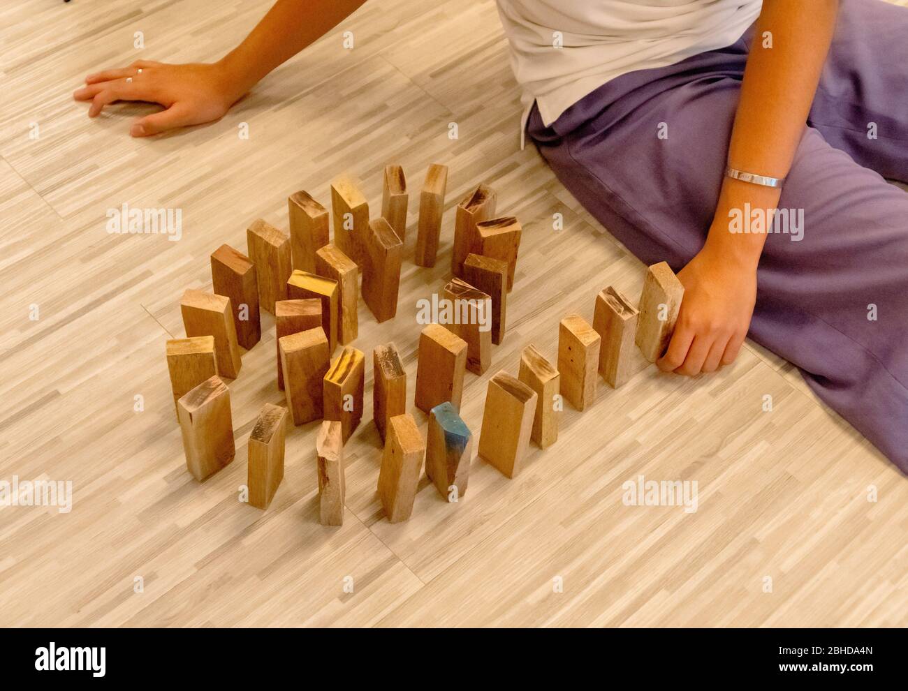 Der Holz-Domino, der von der Hand eines Mannes aufgereiht wird Stockfoto