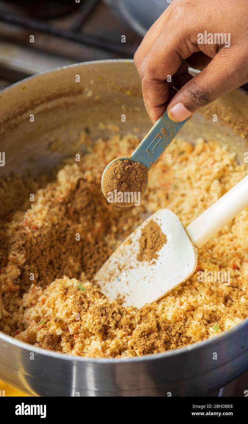 Korianderpulver in gelbe Erbsen gießen, um dhal puri zu machen Stockfoto