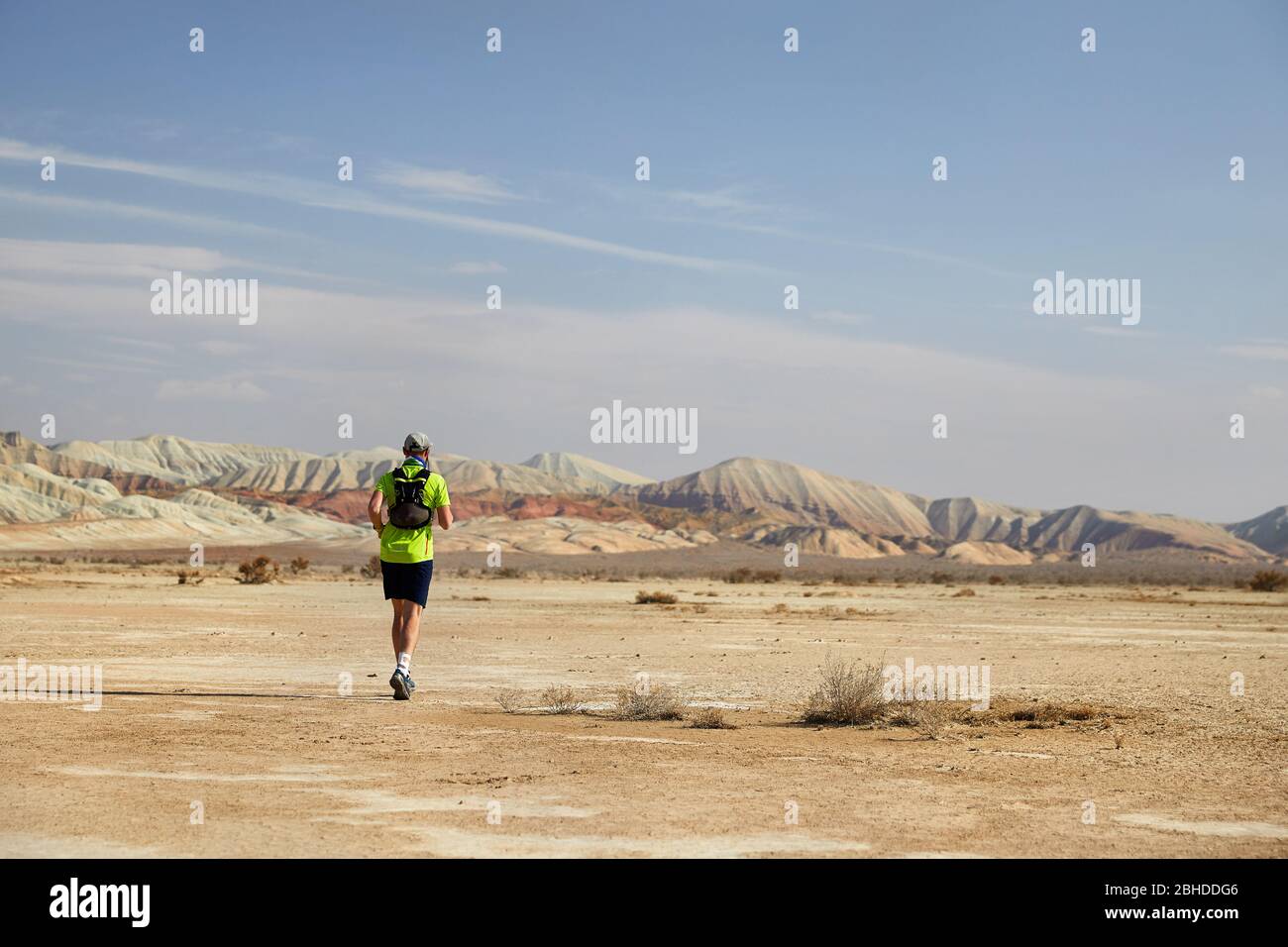 Runner Athlet mit Rucksack auf dem wilden Trail am roten Berge in der Wüste Stockfoto