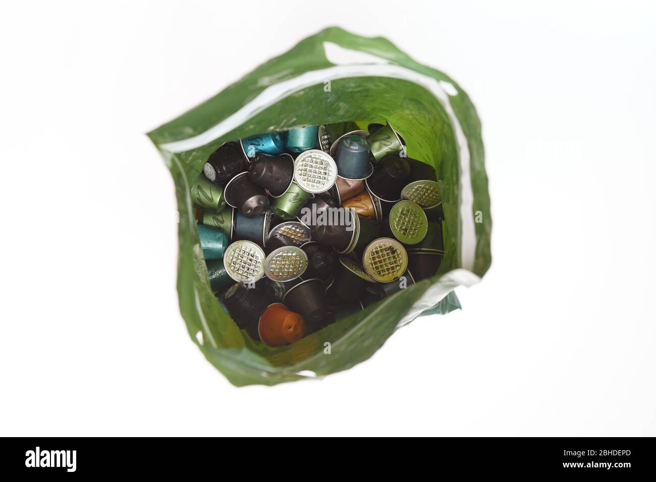 Ein Nespresso Recycling-Beutel, der mit gebrauchten Kaffeekapselschoten auf weißem Hintergrund zur Isolierung verwendet wird. Stockfoto