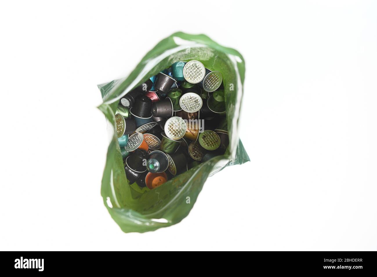 Ein Nespresso Recycling-Beutel, der mit gebrauchten Kaffeekapselschoten auf weißem Hintergrund zur Isolierung verwendet wird. Stockfoto