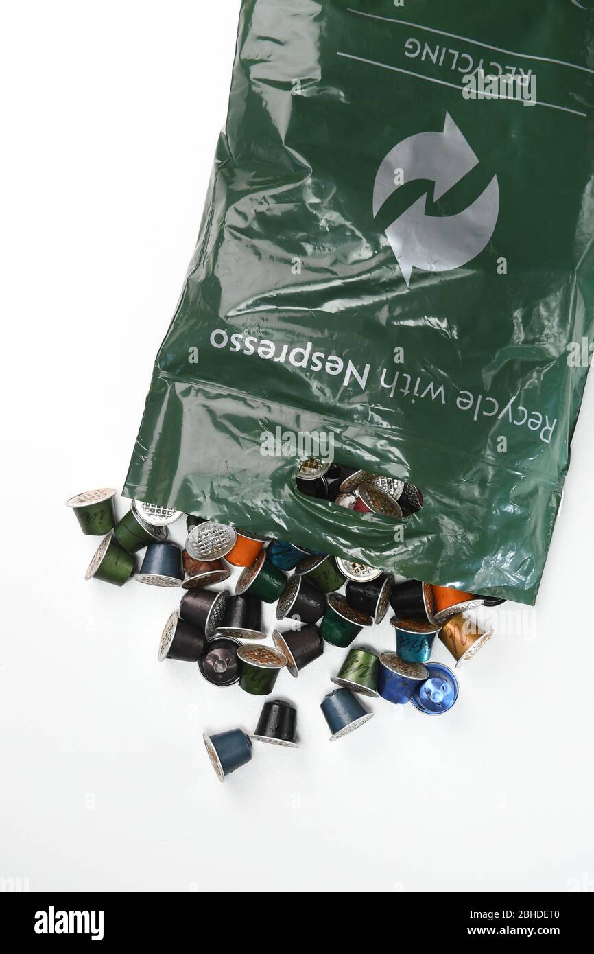 Ein Nespresso Recycling-Beutel, der mit gebrauchten Kaffeekapselschoten auf weißem Hintergrund zur Isolierung verwendet wird. Stockfoto