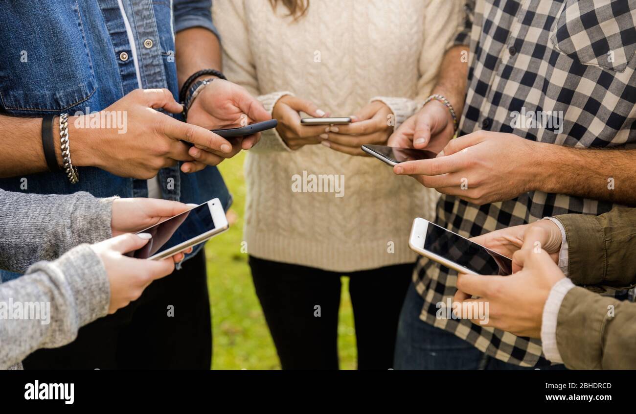 Eine Gruppe von Freunden im Park rumhängen in sozialen Netzwerken Stockfoto