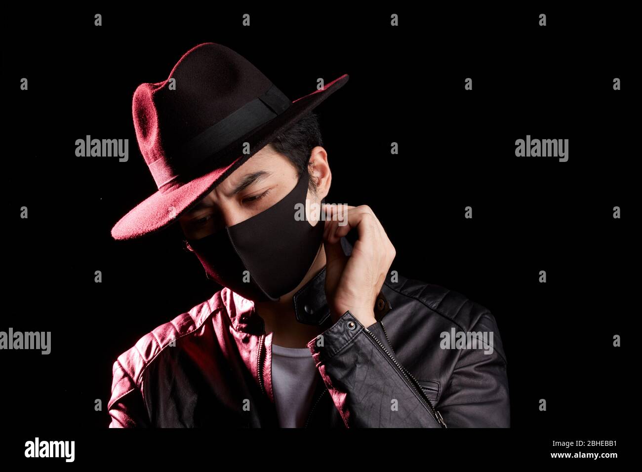 Mann, der in einer schwarzen Gesichtsmaske wegschaut Stockfoto