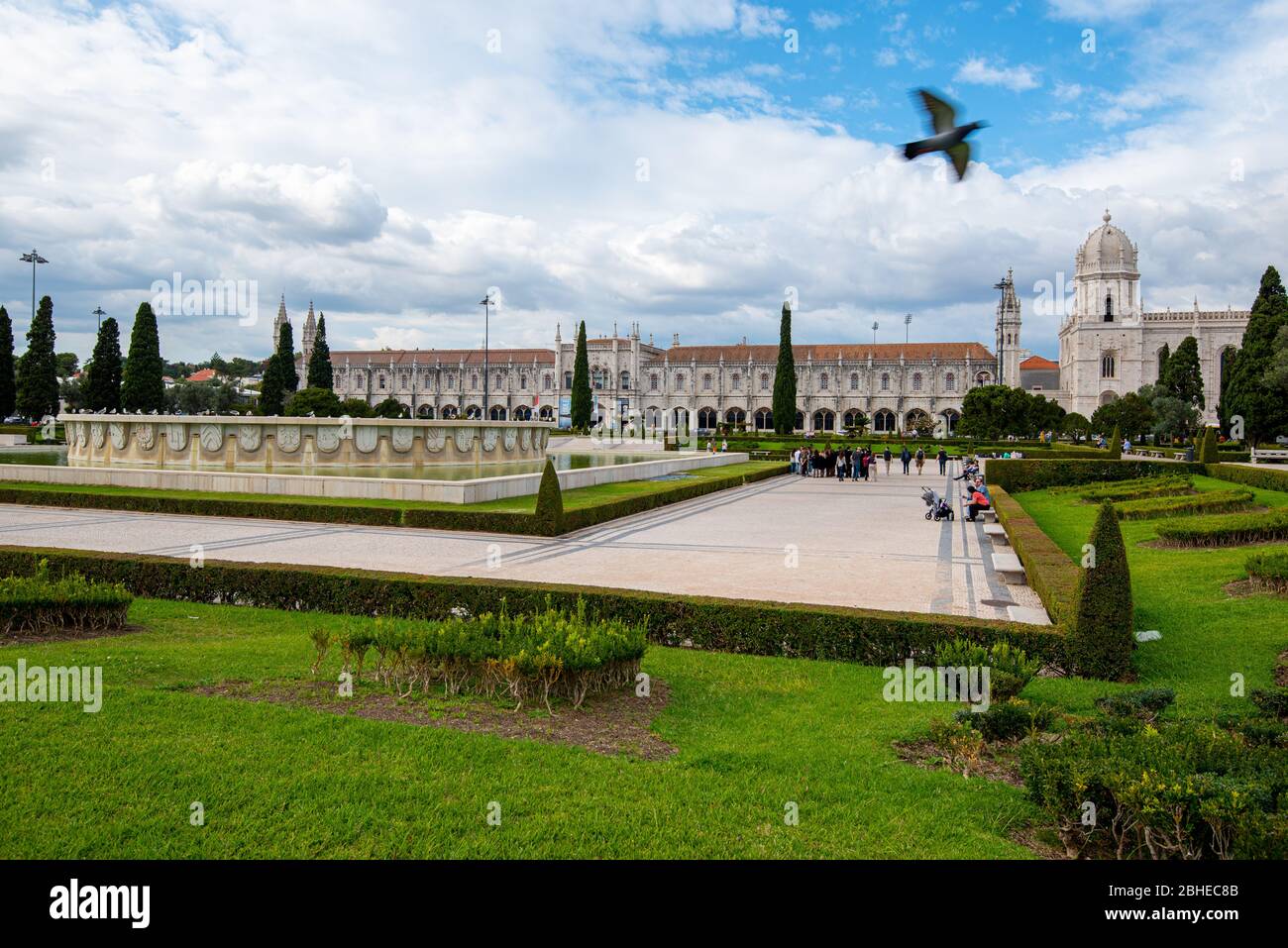 Touristen, die außerhalb des Parks mit Blick auf das Kloster Jeronimos oder Hieronymiten Kloster in der Gemeinde Belem, Lissabon, Portugal, spazieren Stockfoto