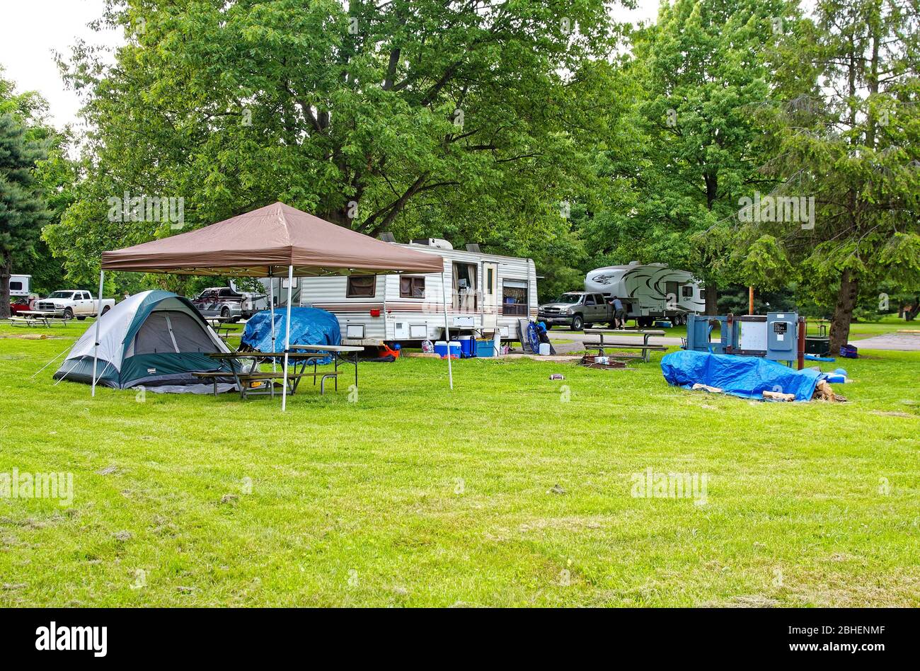 Campingplatz Szene, Reise Anhänger, Zelt, blaue Plane deckt, LKW, Gras, Bäume, Baldachin über Picknick-Tisch, Urlaub, Spaß, Entspannung, Kentucky Horse P Stockfoto