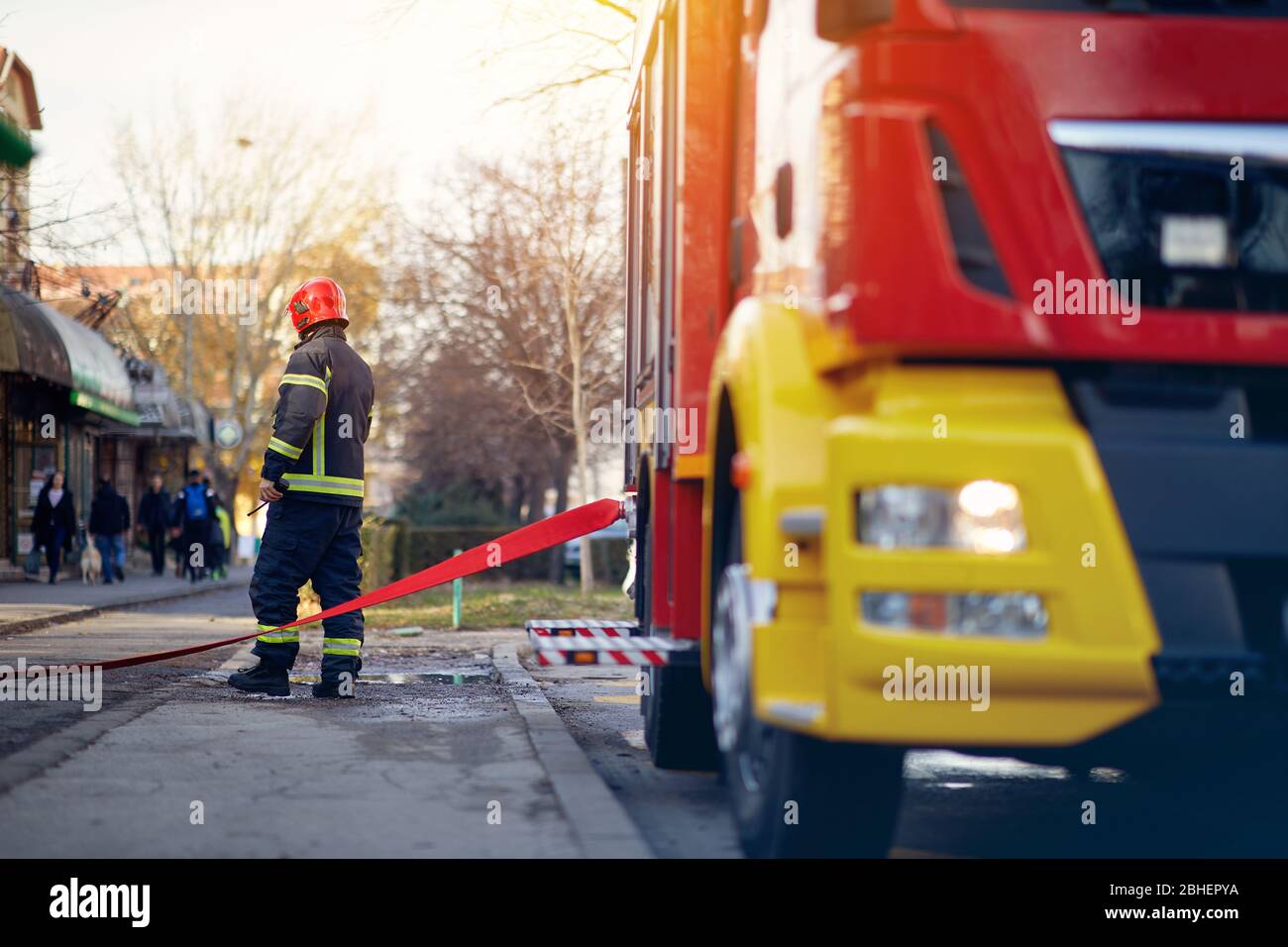 Feuerwehrmann Anschluss einer Feuerwehrschlauch an eine Steckverbindervorrichtung. Feuerwehrmann bei gefährlichen Arbeiten. Stockfoto