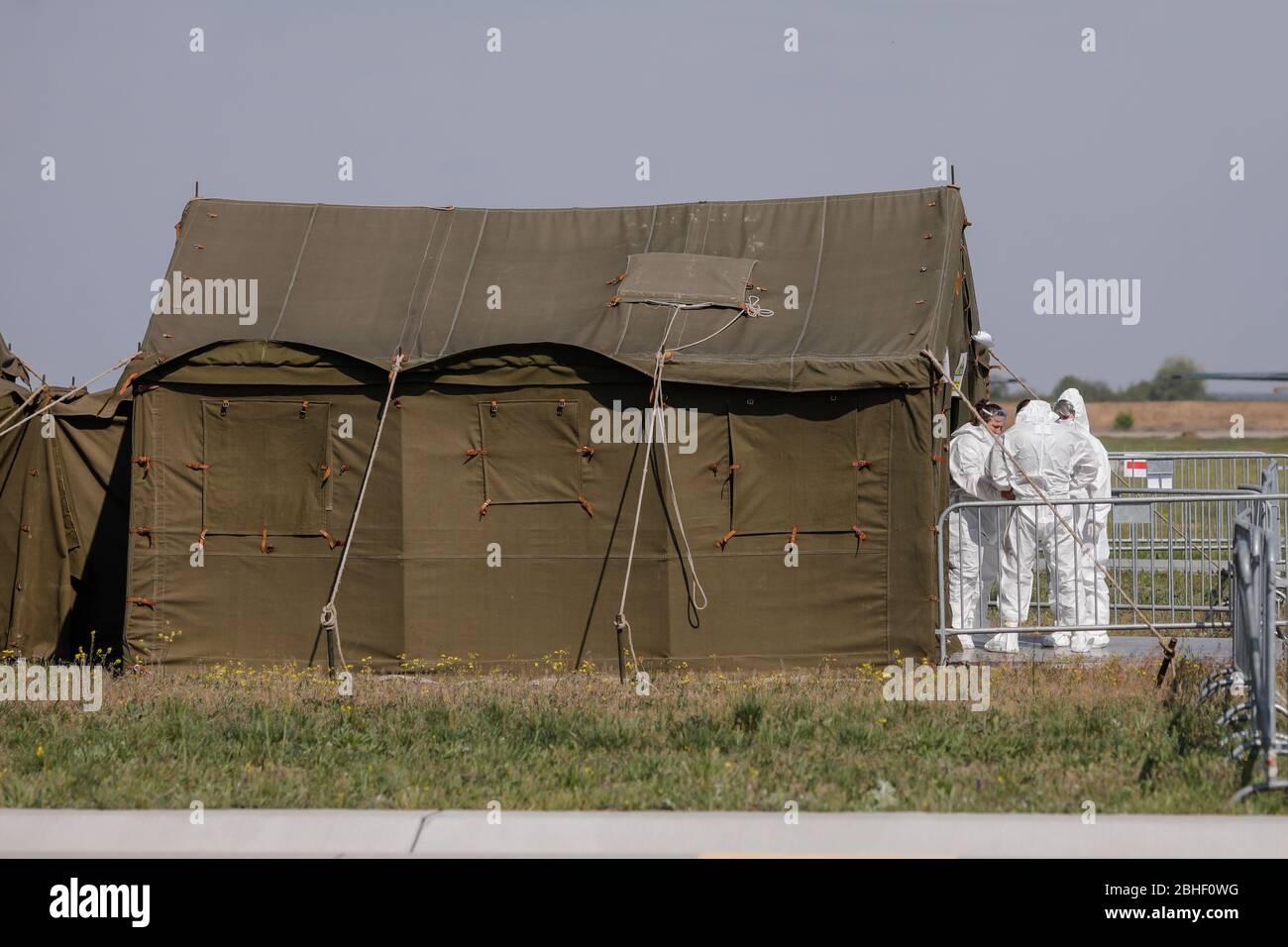 Otopeni, Rumänien - 25. April 2020: Menschen, die Schutzanzüge für Covid-19 in der Nähe eines Militärzeltes auf einem Militärflughafen tragen. Stockfoto