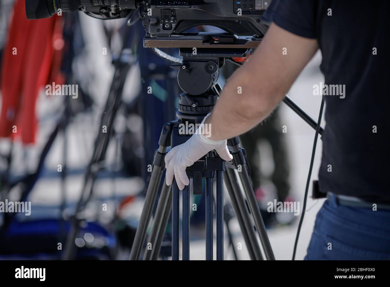 Details mit der Hand in Handschuhen eines Videobedieners während der covid-19-Sperre. Coronavirus und das Pressekonzept. Stockfoto