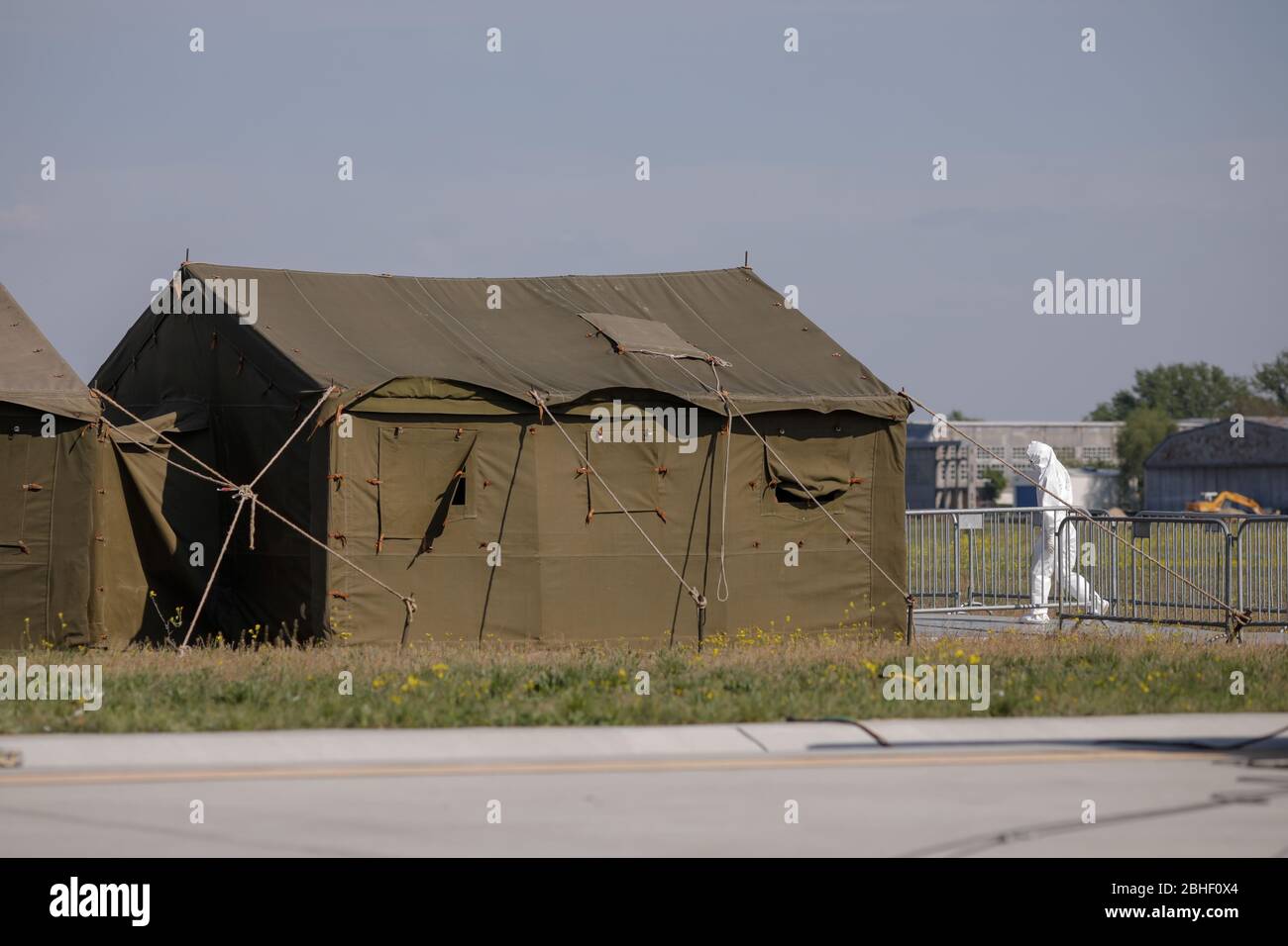 Otopeni, Rumänien - 25. April 2020: Menschen, die Schutzanzüge für Covid-19 in der Nähe eines Militärzeltes auf einem Militärflughafen tragen. Stockfoto