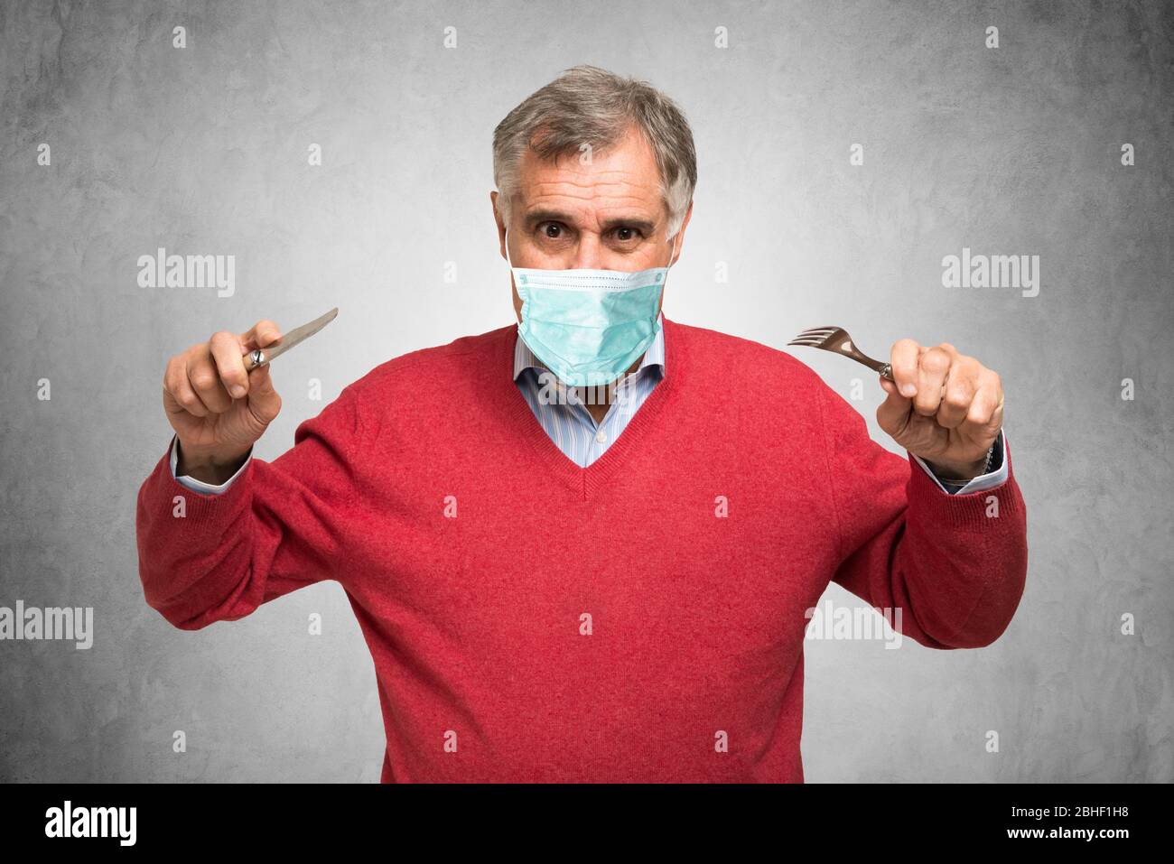 Hungriger Mann mit Maske, Coronavirus Pandemie Konzept Stockfoto