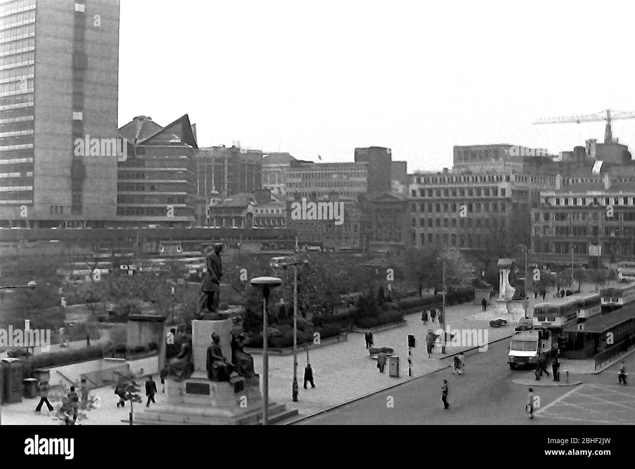 Ein Blick von oben auf Piccadilly Gardens mit der Straße Piccadilly daneben mit Verkehr und Fußgängern in Manchester, England, Großbritannien im Jahr 1974. Die Gärten hatten noch Bäume zu dieser Zeit, lange bevor sie 2002 umgestaltet wurde. Stockfoto