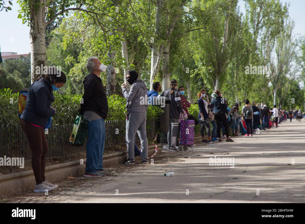 Madrid, Spanien. April 2020. Eine große Schlange von Menschen in der Umgebung des Aluche Nachbarn Vereins warten, während sie den Sicherheitsraum zwischen ihnen zu bewachen, um Nahrung zu erhalten. (Foto von Fer Capdepon Arroyo/Pacific Press/Sipa USA) Quelle: SIPA USA/Alamy Live News Stockfoto