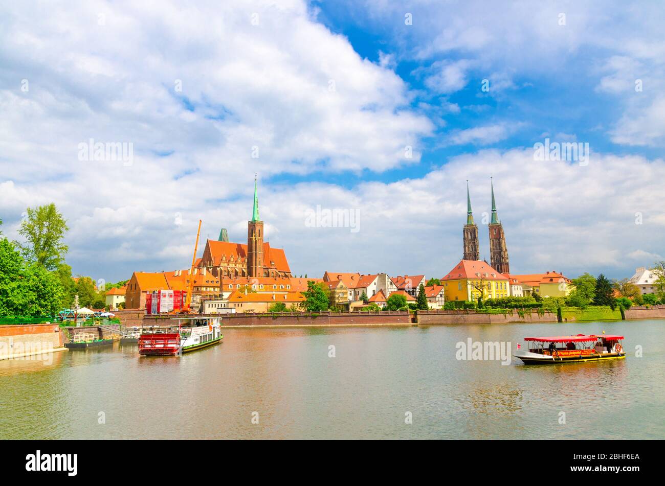 Breslau, Polen, 7. Mai 2019: Panoramablick auf Ostrow Tumski: Stiftskirche Heilig Kreuz und St. Bartholomäus, Kathedrale St. Johannes der Täufer und Boote in der oder Fluss in der historischen Innenstadt Stockfoto