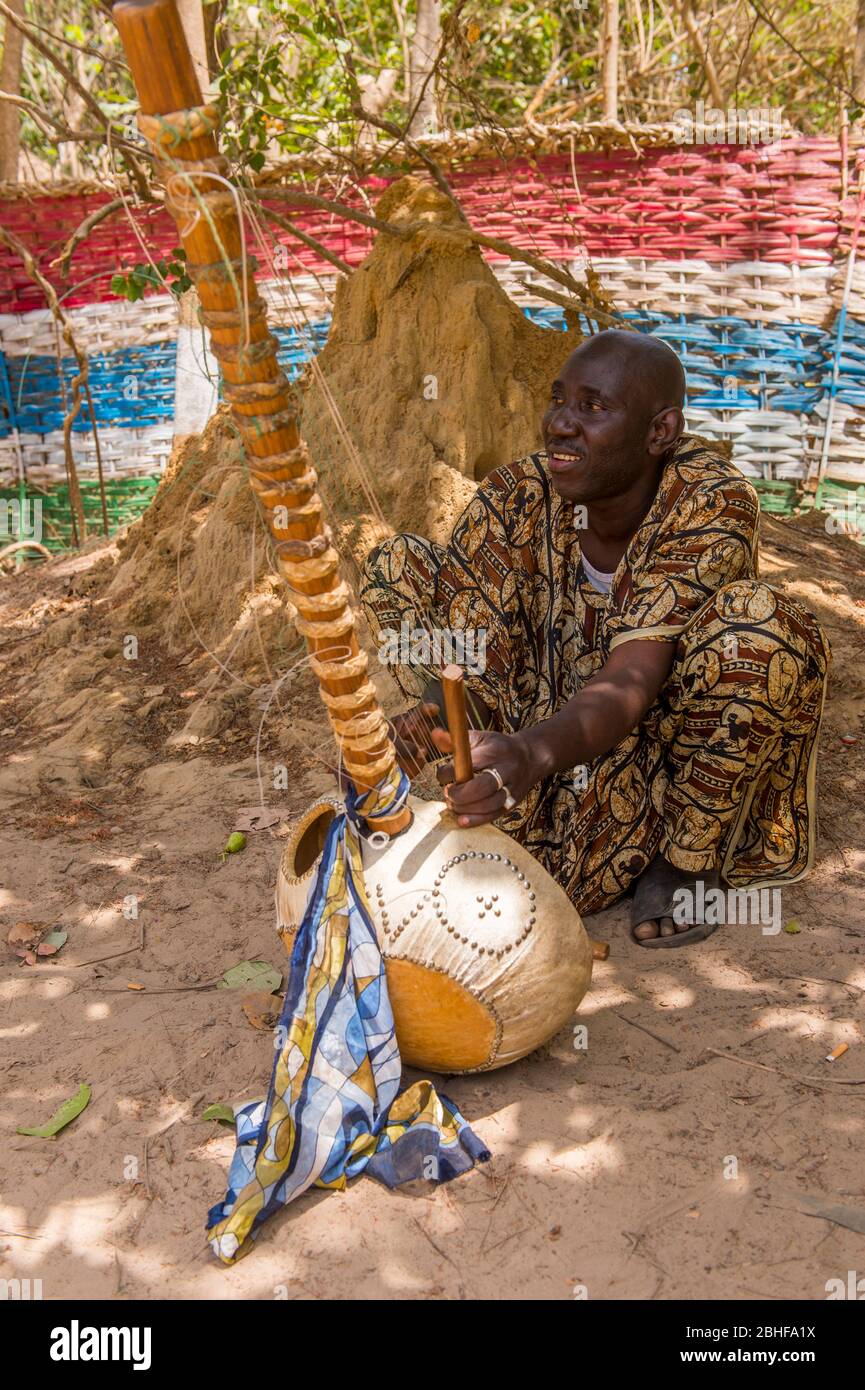 Mann, der ein Kora-Saiteninstrument im Makasutu Cutlure Forest in Gambia spielt. Stockfoto