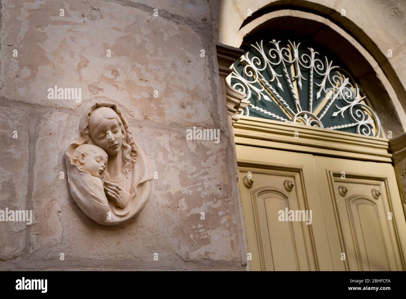 Religiöse Mutter mit Kind an der Wand außerhalb Haus, Mellieha, Malta Stockfoto