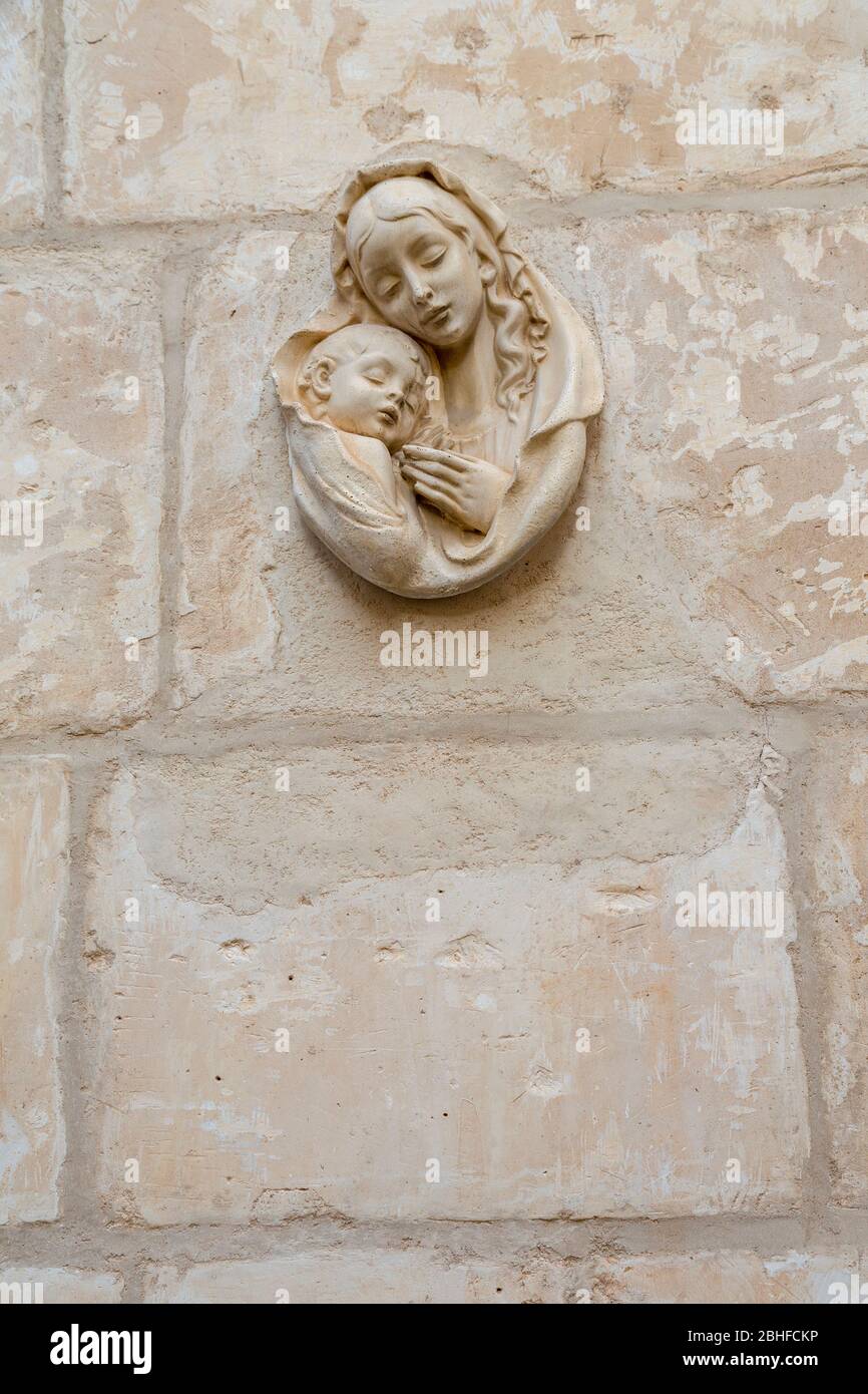 Religiöse Mutter mit Kind an der Wand außerhalb Haus, Mellieha, Malta Stockfoto