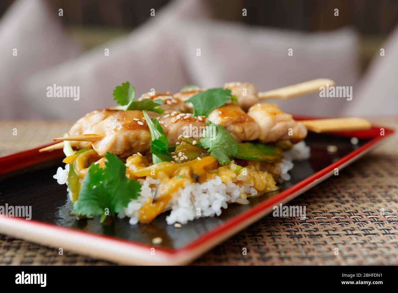 Yakitori-Huhn mit Reis und Koriander auf dem Tisch des Restaurants Stockfoto
