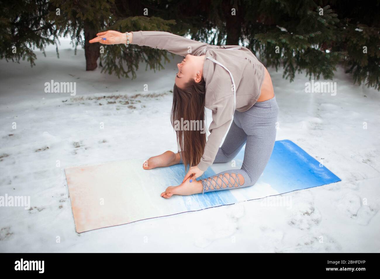 Schönes Mädchen tun Yoga auf der Straße im Winter. Stockfoto