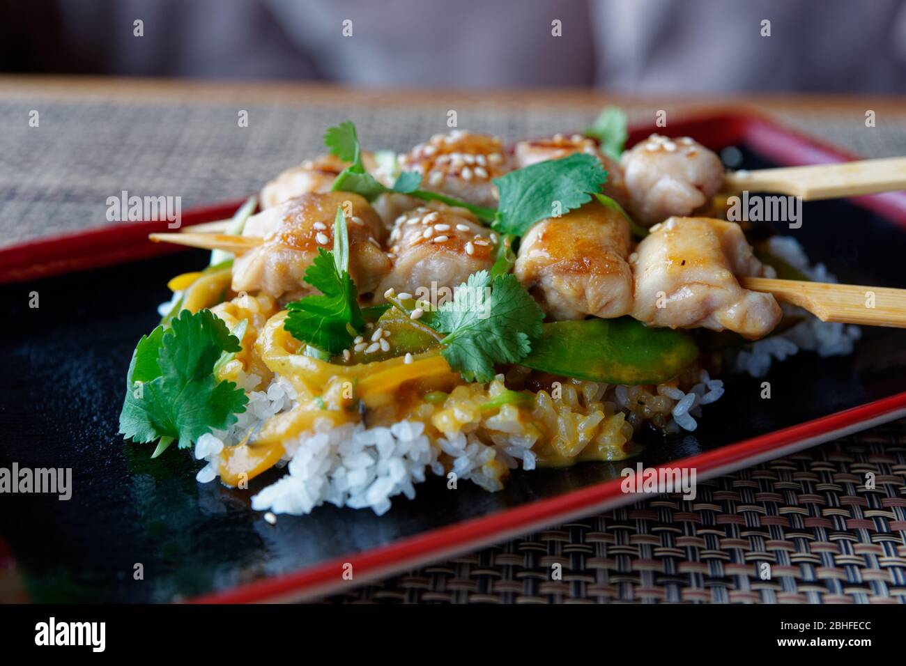 Teriyaki Huhn mit Reis auf dem Tisch im Restaurant, kühler Ton Stockfoto
