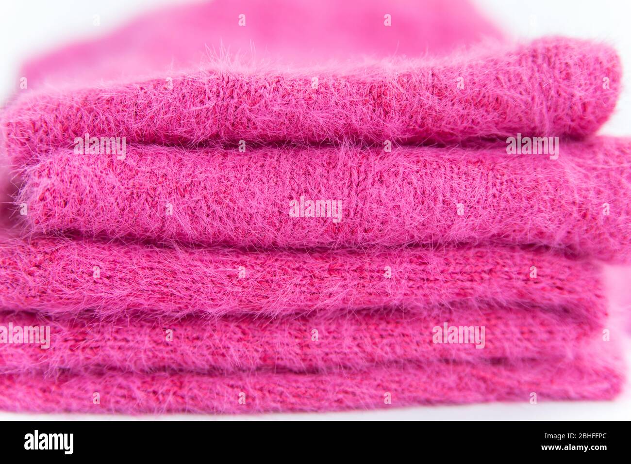 Muster aus rosa Strickpullover Closeup. Handgefertigtes Merinowolle Produkt. Ein Stapel gefalteter Kleidung Stockfoto